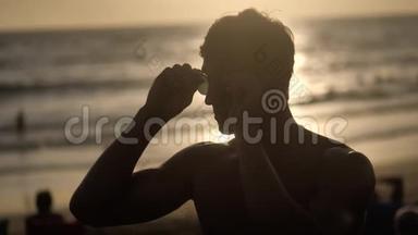 日落时海滩上肌肉<strong>男</strong>的<strong>剪影</strong>。
